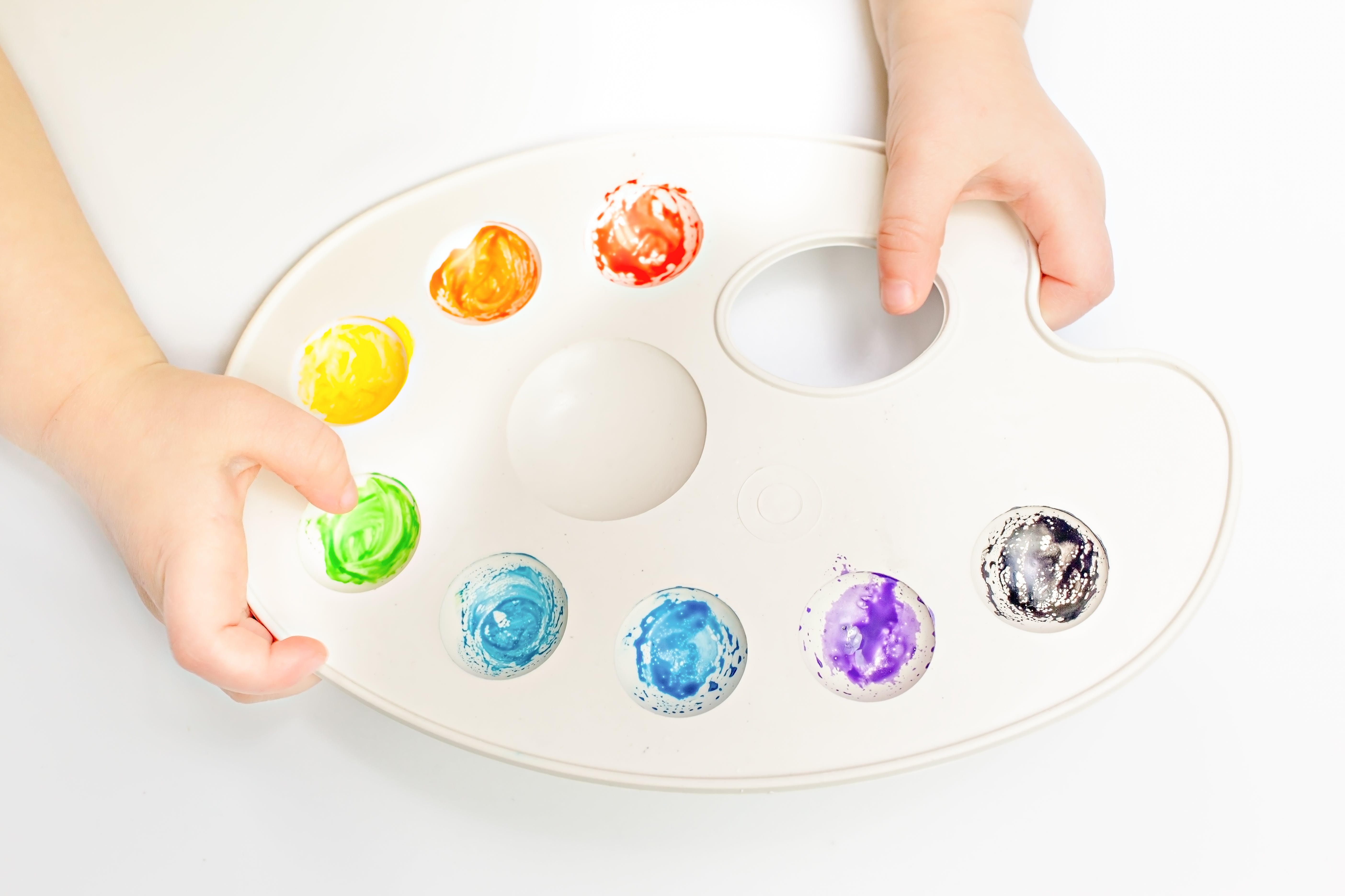 A paint palette is held by a child.