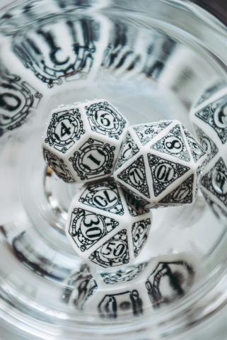 Three black and with dice are reflected in glass.