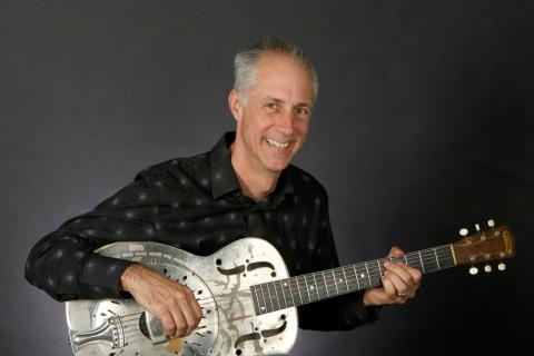 Photo of Stuart Stotts holding a guitar
