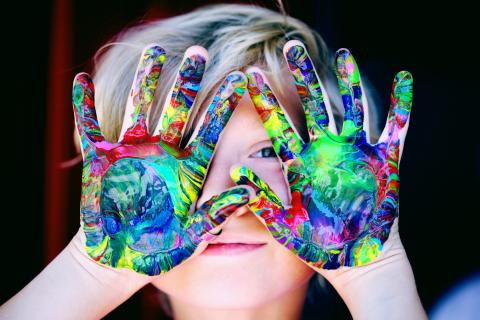 A child with paint on their hands.