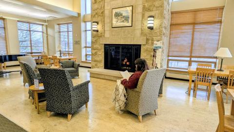 woman reading in armchair at library