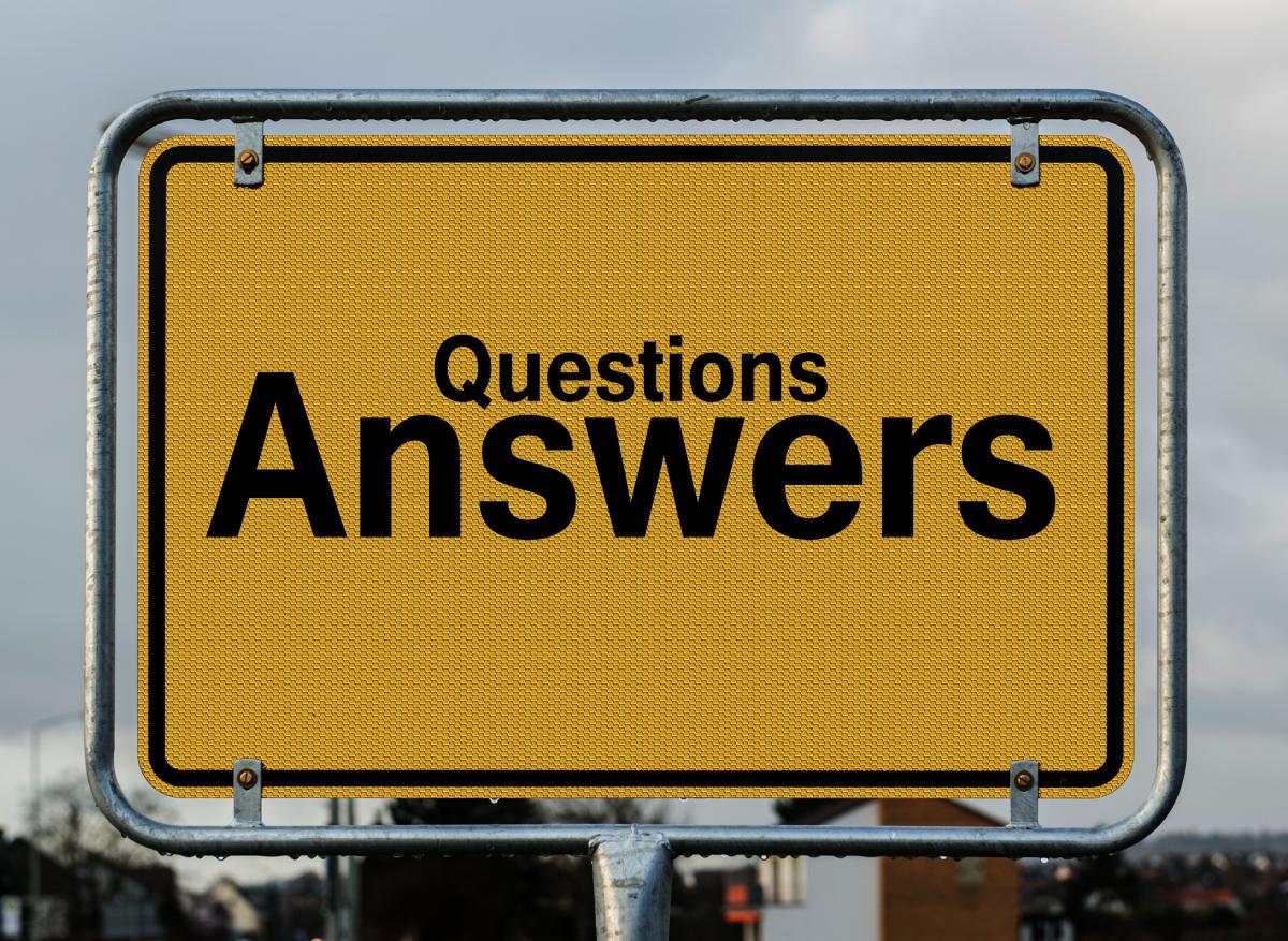 A yellow rectangular sign with black writing, "Questions Answers".